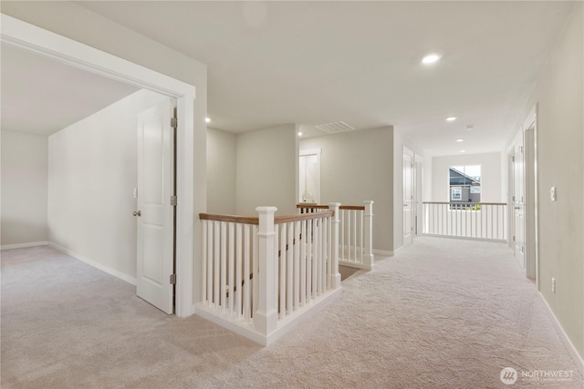hallway featuring an upstairs landing, carpet flooring, baseboards, and recessed lighting