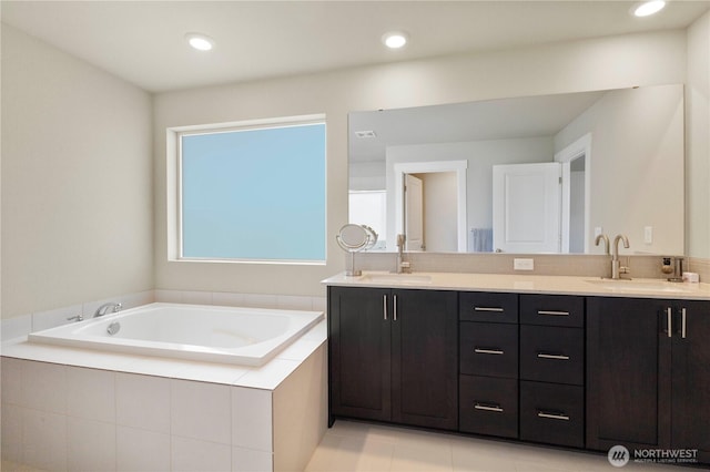 bathroom featuring a garden tub, double vanity, and tile patterned flooring