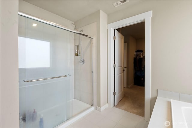 bathroom with a shower stall, a spacious closet, and baseboards