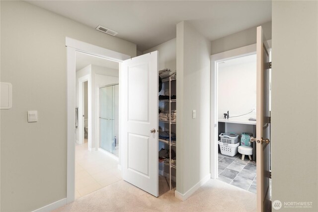 hallway with baseboards and light carpet