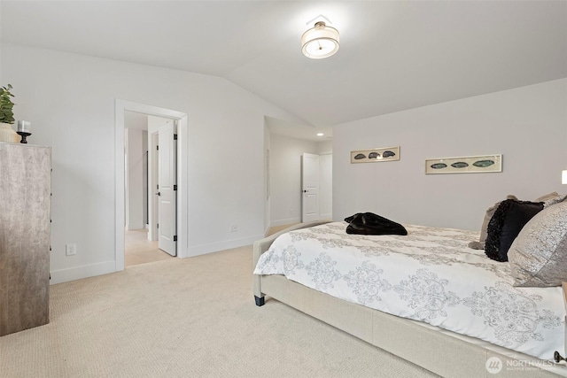 bedroom featuring vaulted ceiling, light carpet, and baseboards