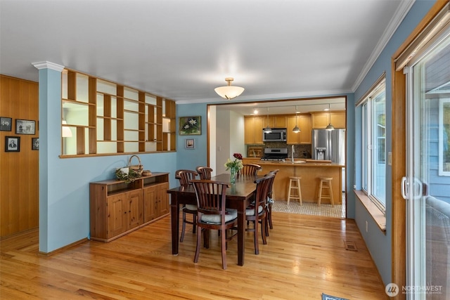 10051 45th Ave NE, Seattle, WA 98125 - dining area with ornamental molding, light wood-style flooring, and baseboards