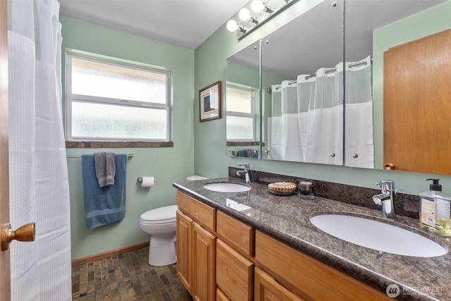 10051 45th Ave NE, Seattle, WA 98125 - full bath featuring double vanity, baseboards, toilet, a shower with shower curtain, and stone finish flooring