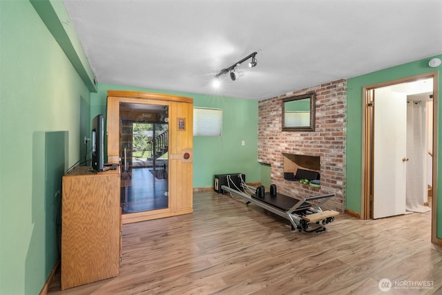 10051 45th Ave NE, Seattle, WA 98125 - living area featuring wood finished floors, a brick fireplace, track lighting, and baseboards