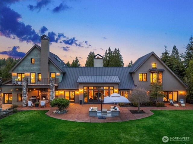 30404 44th Ave NW, Stanwood, WA 98292 - back of house at dusk with a chimney, a patio area, and a yard