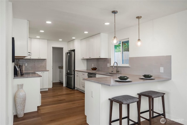 21326 5th Ave S, Des Moines, WA 98198 - kitchen with a sink, stainless steel appliances, a peninsula, backsplash, and white cabinetry
