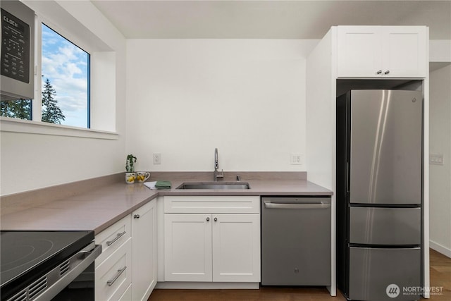 21326 5th Ave S, Des Moines, WA 98198 - kitchen featuring stainless steel appliances, a sink, white cabinets, and light countertops