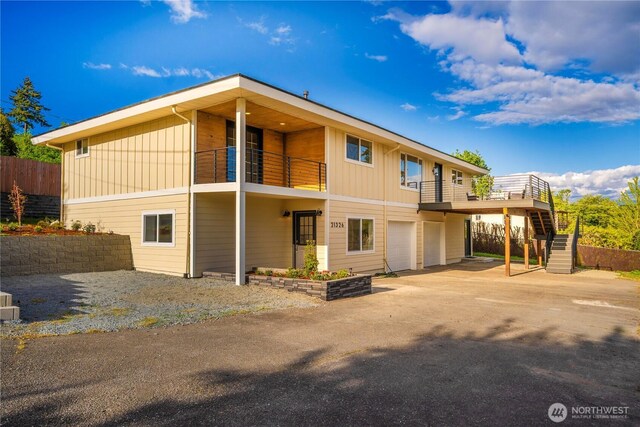 21326 5th Ave S, Des Moines, WA 98198 - rear view of house with a garage, a balcony, driveway, stairway, and board and batten siding