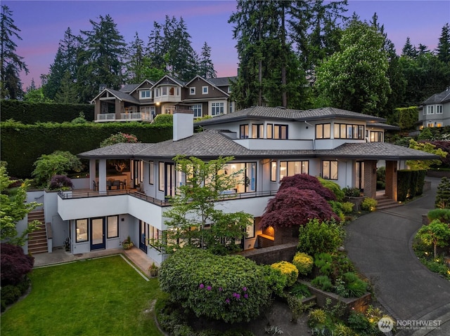 8902 N Mercer Way, Mercer Island, WA 98040 - view of front facade with stucco siding, a balcony, and a front yard
