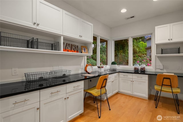 8902 N Mercer Way, Mercer Island, WA 98040 - kitchen with open shelves, white cabinets, light wood finished floors, recessed lighting, and dark countertops
