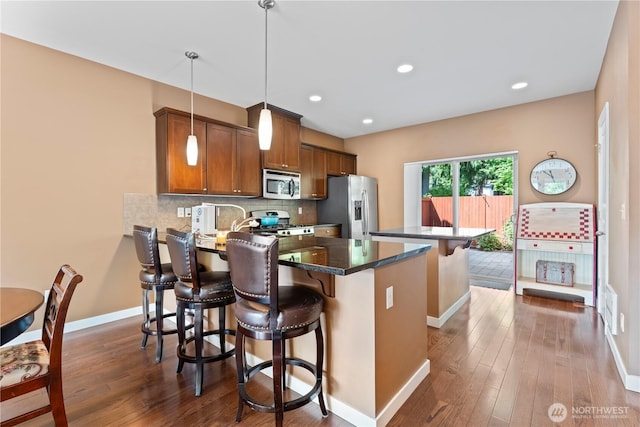 16404 1st Dr SE, Bothell, WA 98012 - kitchen featuring stainless steel appliances, a peninsula, baseboards, brown cabinets, and a kitchen breakfast bar