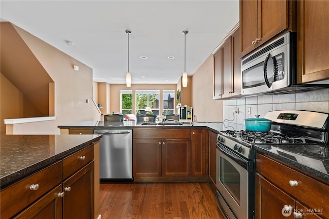 16404 1st Dr SE, Bothell, WA 98012 - kitchen featuring stainless steel appliances, dark wood-style floors, a peninsula, a sink, and hanging light fixtures