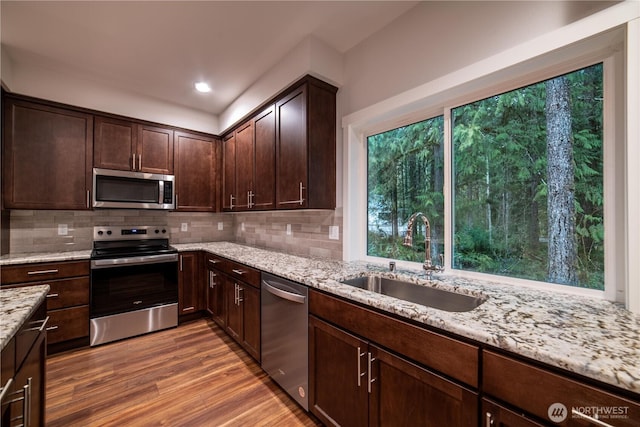 8570 Trillium Ln, Concrete, WA 98237 - kitchen with stainless steel appliances, a sink, light wood finished floors, light stone countertops, and dark brown cabinetry