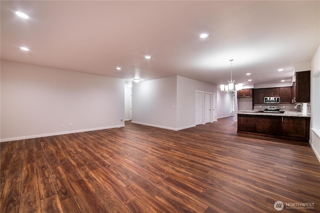 8570 Trillium Ln, Concrete, WA 98237 - unfurnished living room with a chandelier, recessed lighting, dark wood-style floors, baseboards, and a sink