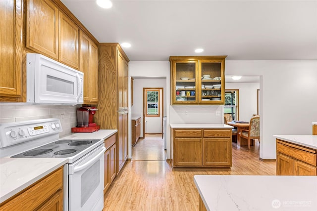 8368 Birdsview Meadows Ln, Concrete, WA 98237 - kitchen featuring white appliances, light wood-style floors, decorative backsplash, glass insert cabinets, and brown cabinetry