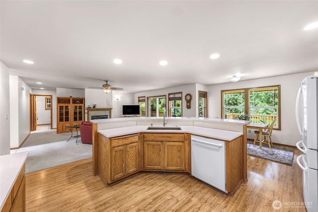 8368 Birdsview Meadows Ln, Concrete, WA 98237 - kitchen featuring white appliances, a sink, light countertops, a tiled fireplace, and healthy amount of natural light