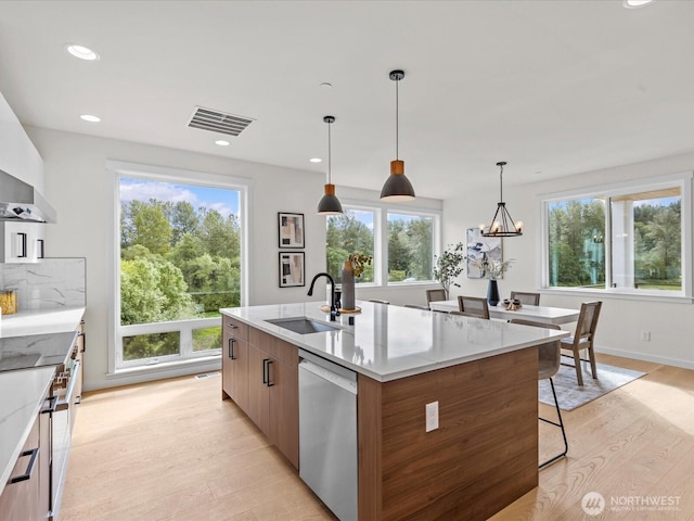 667 17th Ave NW, Issaquah, WA 98027 - kitchen with dishwasher, a sink, light wood-type flooring, modern cabinets, and plenty of natural light