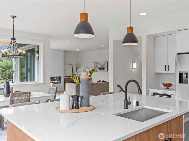 667 17th Ave NW, Issaquah, WA 98027 - kitchen featuring a sink, stainless steel fridge, light stone counters, modern cabinets, and recessed lighting