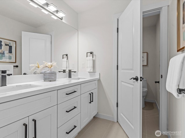 667 17th Ave NW, Issaquah, WA 98027 - bathroom with toilet, tile patterned flooring, double vanity, and baseboards