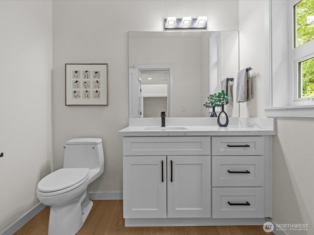 667 17th Ave NW, Issaquah, WA 98027 - bathroom featuring toilet, vanity, baseboards, and wood finished floors