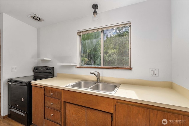 21813 223rd Pl SE, Maple Valley, WA 98038 - kitchen featuring black electric range oven, a sink, light countertops, and brown cabinets