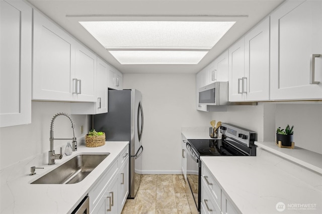 3425 Colby Ave Unit 502, Everett, WA 98201 - kitchen featuring appliances with stainless steel finishes, a sink, white cabinets, and light stone countertops