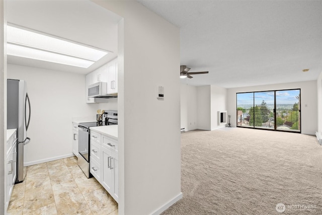 3425 Colby Ave Unit 502, Everett, WA 98201 - kitchen with stainless steel appliances, white cabinetry, a ceiling fan, light countertops, and baseboards