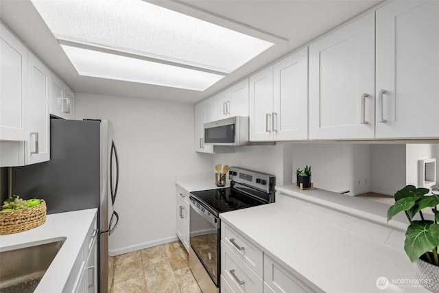 3425 Colby Ave Unit 502, Everett, WA 98201 - kitchen with stainless steel appliances, baseboards, white cabinetry, and a sink