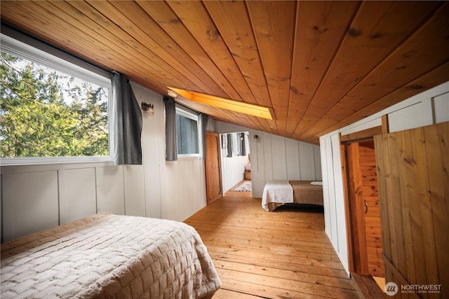 bedroom with lofted ceiling, hardwood / wood-style flooring, wood ceiling, and wooden walls