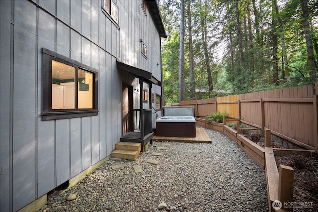 view of yard with a hot tub, fence, and a vegetable garden