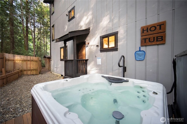 view of patio / terrace featuring a hot tub and fence