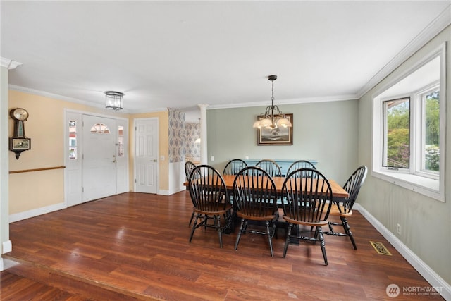 dining area with wood finished floors, a chandelier, baseboards, and crown molding