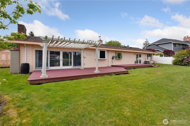 back of house featuring a pergola, a wooden deck, a storage unit, and an outdoor structure