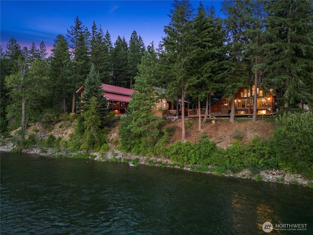 aerial overview of property's location featuring a nearby body of water and a forest