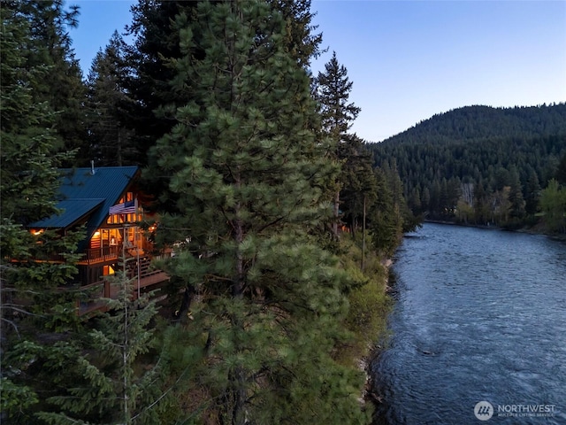 water view with a heavily wooded area and a mountainous background