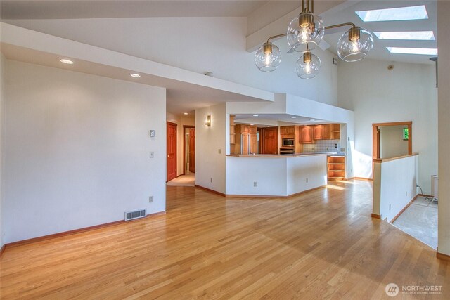 55 Langell Ln, Orcas Island, WA 98245 - unfurnished living room featuring high vaulted ceiling, a skylight, baseboards, light wood-style flooring, and recessed lighting