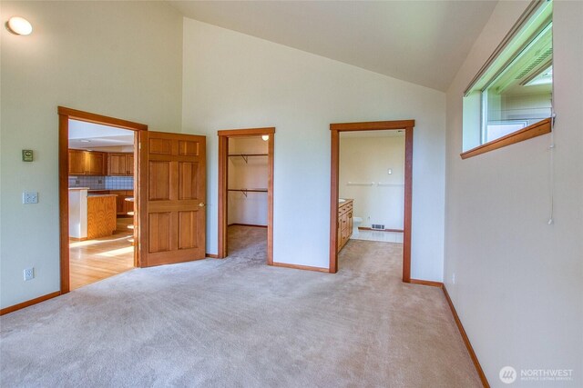 55 Langell Ln, Orcas Island, WA 98245 - unfurnished bedroom with a walk in closet, carpet flooring, baseboards, and high vaulted ceiling