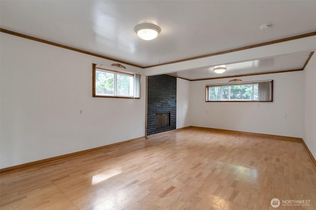 14502 Main St, Bellevue, WA 98007 - unfurnished living room with ornamental molding, a brick fireplace, light wood-style flooring, and healthy amount of natural light