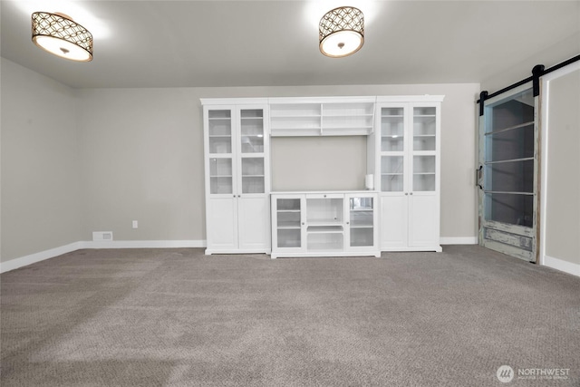 13800 27th Dr NW, Tulalip, WA 98271 - unfurnished living room featuring carpet floors, a barn door, and baseboards