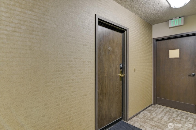doorway to outside featuring a textured ceiling
