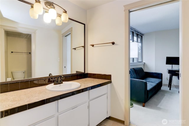 bathroom with vanity, toilet, and baseboards