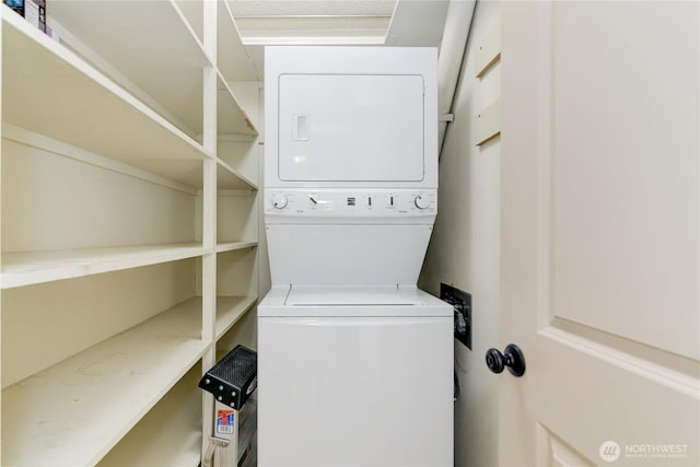 clothes washing area featuring stacked washer / dryer