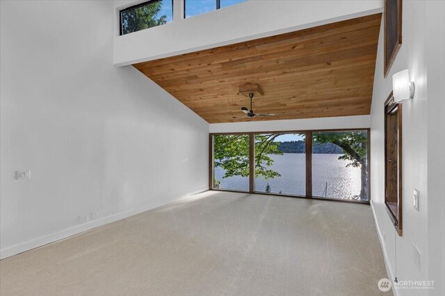 16015 Inglewood Rd NE, Kenmore, WA 98028 - empty room featuring carpet, lofted ceiling, wood ceiling, baseboards, and a water view