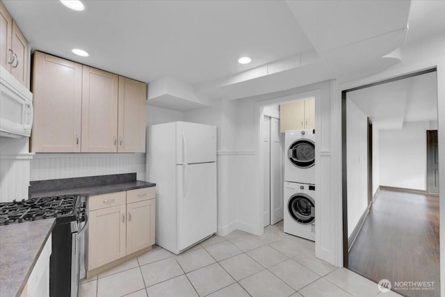 16015 Inglewood Rd NE, Kenmore, WA 98028 - kitchen featuring white appliances, stacked washer / dryer, light tile patterned floors, recessed lighting, and dark countertops