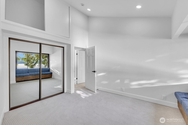16015 Inglewood Rd NE, Kenmore, WA 98028 - unfurnished bedroom featuring baseboards, carpet floors, recessed lighting, a towering ceiling, and a closet