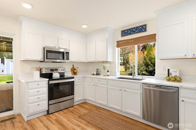 17427 92nd Ave NE, Bothell, WA 98011 - kitchen featuring stainless steel appliances, a sink, light wood finished floors, white cabinets, and recessed lighting