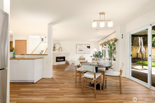 17427 92nd Ave NE, Bothell, WA 98011 - dining space with light wood finished floors, a tiled fireplace, and baseboards