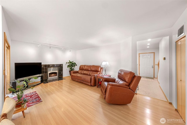 163 Polo Park Dr, Bellingham, WA 98229 - living area with track lighting, light wood-style flooring, and a tiled fireplace