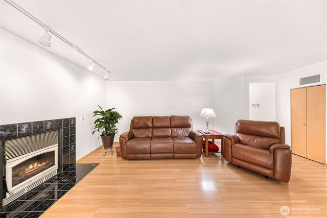 163 Polo Park Dr, Bellingham, WA 98229 - living room with wood finished floors, a tiled fireplace, and rail lighting