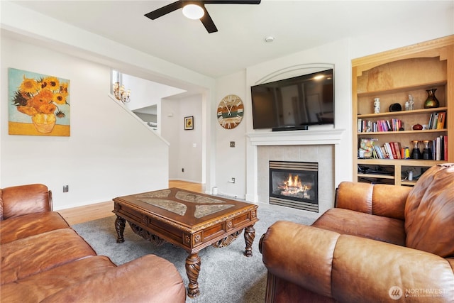 living room with ceiling fan, a fireplace, and wood finished floors